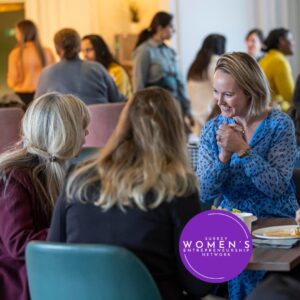 Women entrepreneurs excitedly talking at a table over lunch