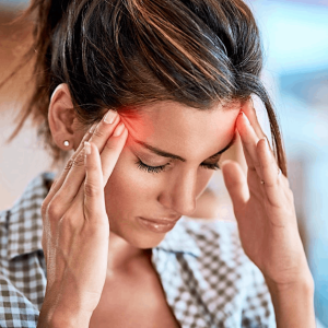 Woman holding her head because of a migraine
