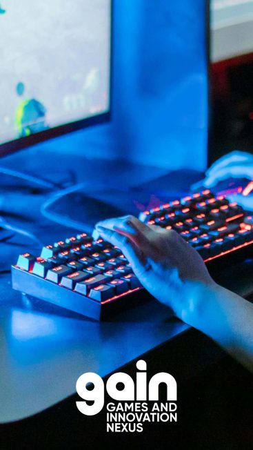Fingers on a keyboard in a neon-lit gamer space