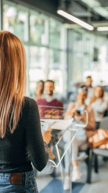 A woman addresses a room of people