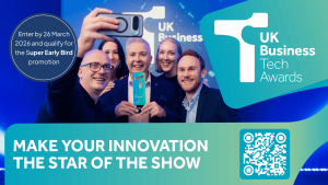 A group of winners pose for a photograph on a poster advertising the UK Business Tech Awards 2026
